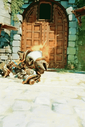 a video game character is laying on the ground in front of a castle door