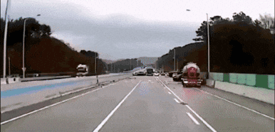 a car is driving down a highway next to a truck that has the letter r on it