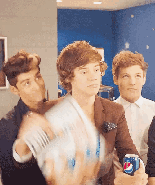 a man in a brown suit holds a pepsi can