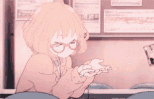 a girl wearing glasses is sitting at a table with a cup of coffee in her hand .