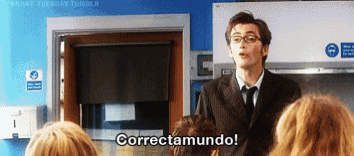 a man in a suit and tie is standing in front of a group of people and says correctamundo