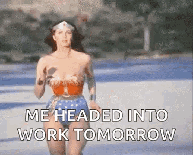a woman in a wonder woman costume is running down a street .
