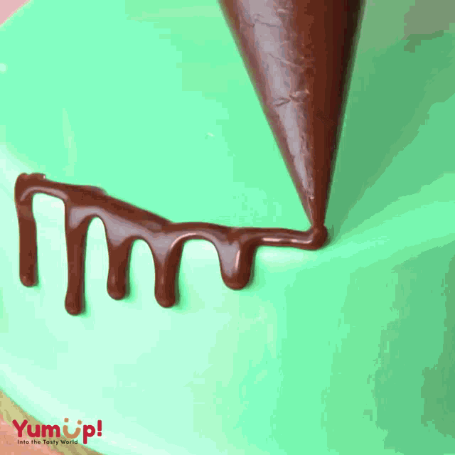 a cake is being decorated with chocolate and the word yumup is on the bottom right