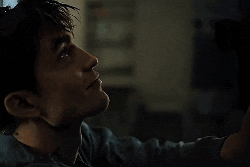 a close up of a man looking up at something in the dark
