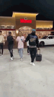 a group of people are walking in front of a wendy 's restaurant