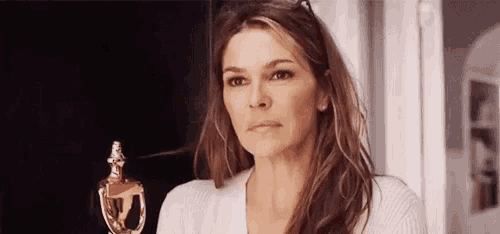 a woman is holding a trophy and making a face .