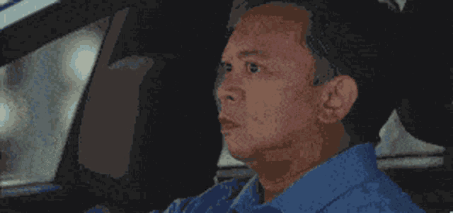 a man in a car gives a thumbs up