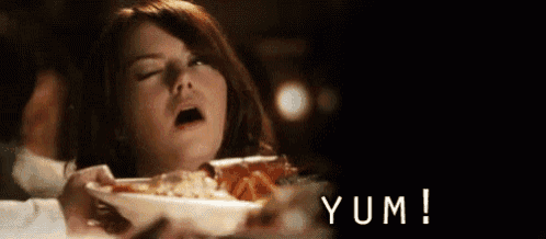 a woman is sitting at a table with her mouth open and the word yum is on the bottom right