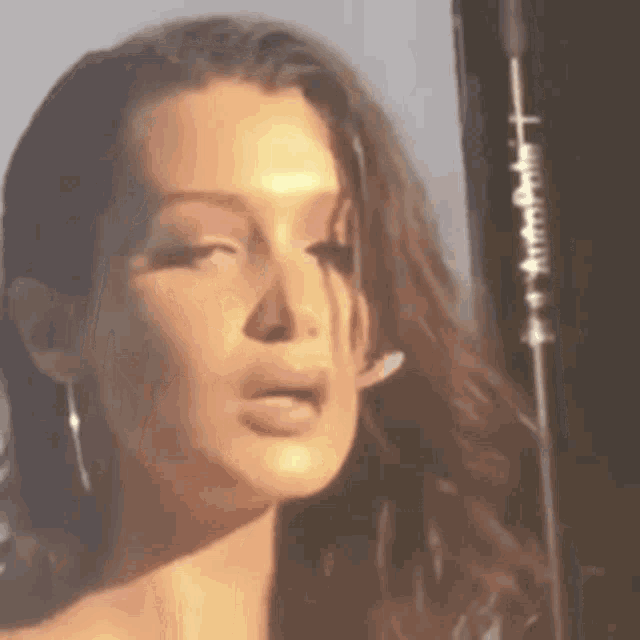 a close up of a woman 's face with her mouth open and a microphone in the background .