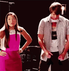 a man and a woman are standing next to each other . the woman is wearing a pink dress .
