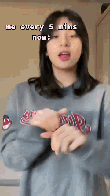 a girl in a gray sweatshirt is making a funny face .