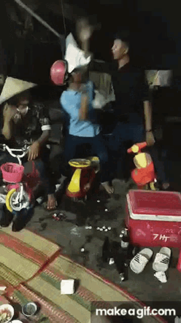 a group of people are sitting around a red cooler that says 7 hp on it