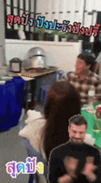 a group of people are clapping in a room with foreign writing on the walls