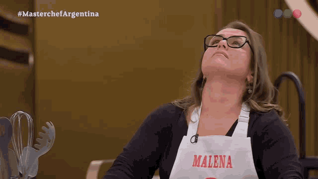 a woman wearing glasses and an apron with malena written on it