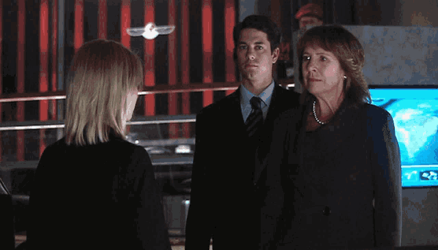 a man in a suit and tie stands next to a woman in a black dress