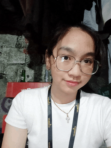 a young woman wearing glasses and a lanyard that says cobra