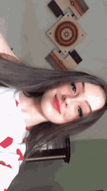 a girl is taking a selfie in front of a painting on the wall .