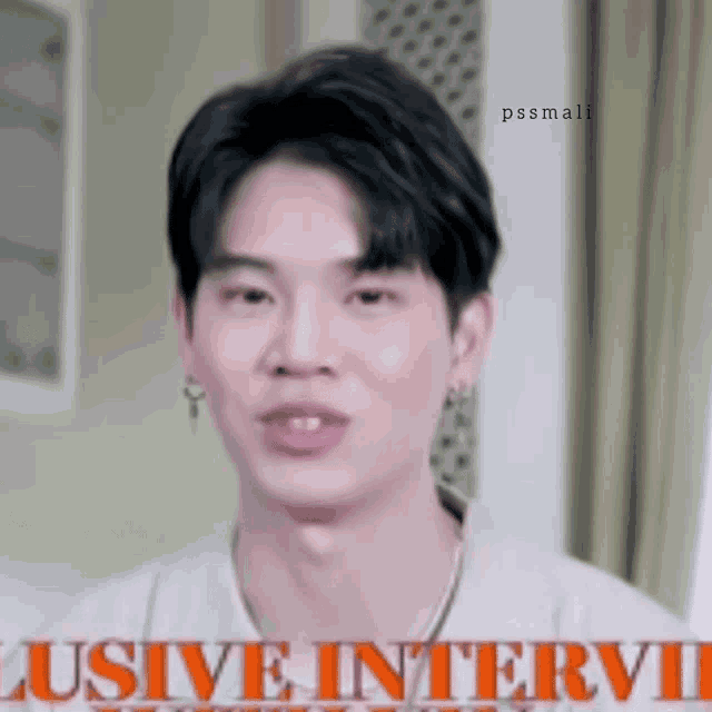 a close up of a man 's face with the words ' exclusive interview ' written above him .