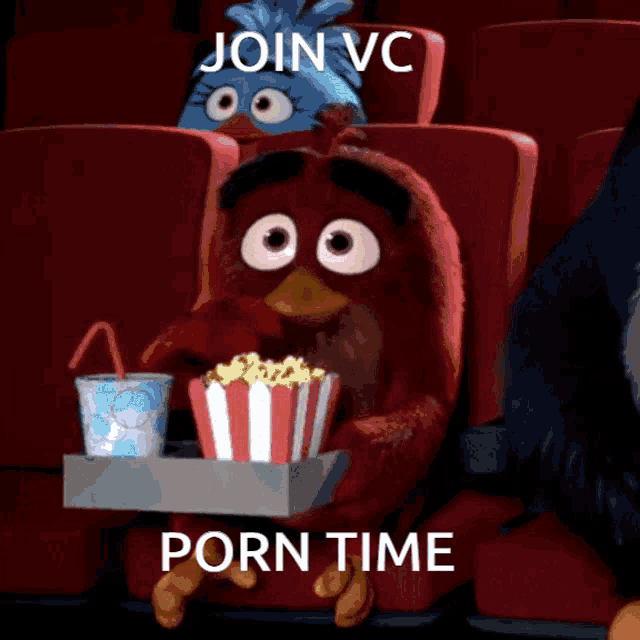 an angry bird is sitting in a movie theater holding a tray of popcorn and soda