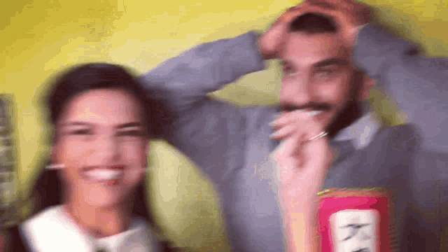 a man and a woman are posing for a picture with a can of ketchup in the foreground .
