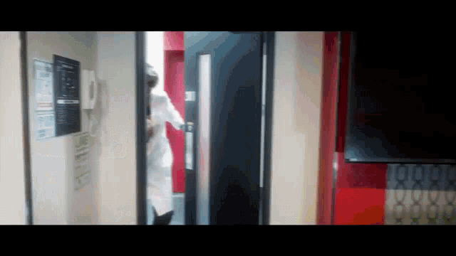 a person in a lab coat is walking through a doorway