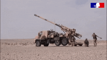 a group of soldiers are standing in the desert near a military vehicle