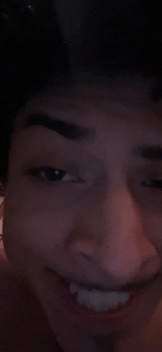 a close up of a person 's face with a smile on it and a black background .