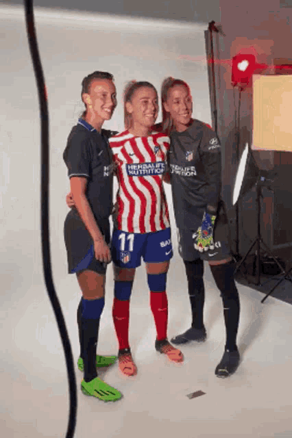 three female soccer players are posing for a picture with one wearing a number 11 jersey