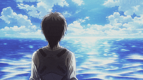 a person looking out over a body of water with a blue sky