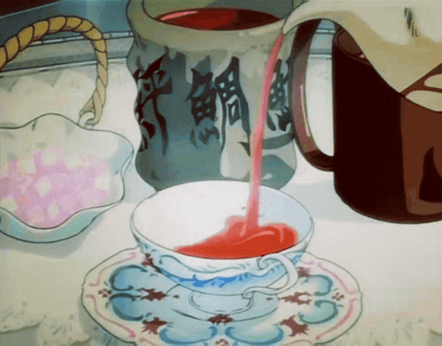 a cup of tea is being poured into a saucer next to a pitcher with chinese writing on it