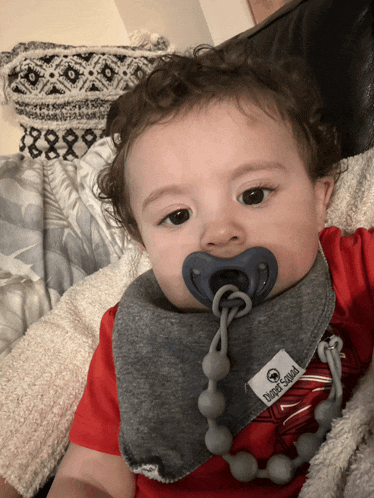 a baby wearing a pacifier and a bib that says tuff squad on it