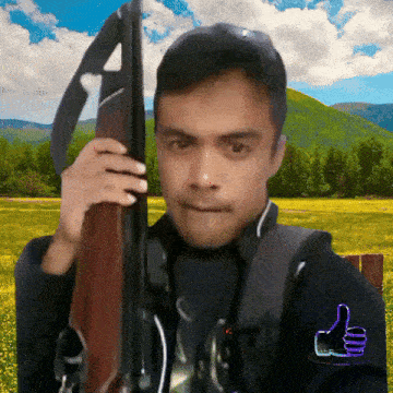 a man holding a gun with a thumbs up
