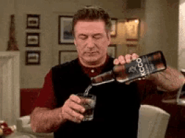 a man is pouring a glass of alcohol from a bottle that says xcoo on it