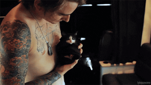 a shirtless tattooed man holds a black cat in his arms with the caption " mepavone "