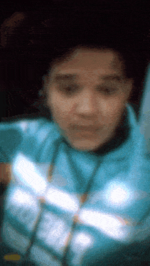 a blurry photo of a person wearing a blue jacket with the word adidas on it