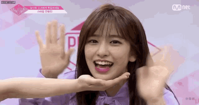 a young woman in a purple shirt is making a face with her hands .