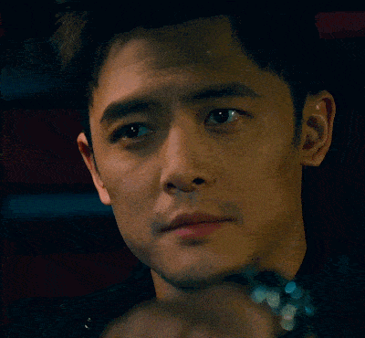 a close up of a man 's face with a watch on his wrist