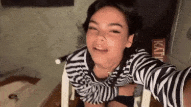 a young girl in a zebra print shirt is taking a selfie .