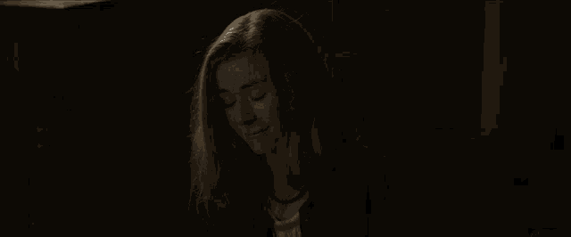 a woman is sitting in a dark room and says i can 't .