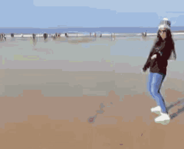 a woman is standing on a beach with her arms outstretched and the word free written in the sand