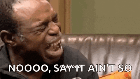 a man is crying while sitting on a couch and saying `` noooo , say it ain t so '' .