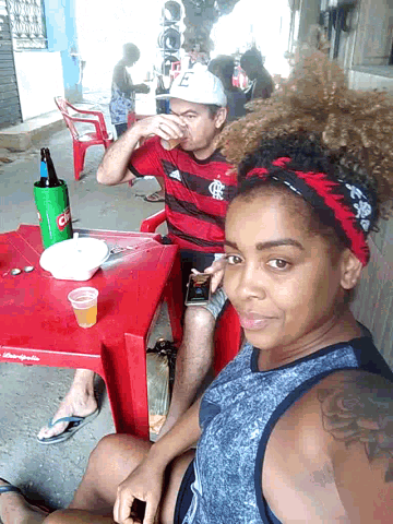 a man and a woman sit at a table with a coca cola bottle