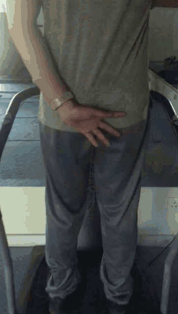 a person standing on a treadmill with their hands on their butt
