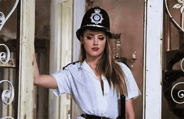 a woman dressed as a police officer is standing in a doorway .