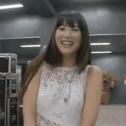 a woman in a white dress is smiling and laughing .
