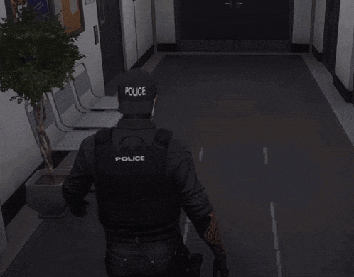 a man wearing a black vest that says police on it