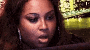 a close up of a woman 's face with her mouth open