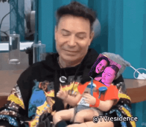 a man is holding a baby in his arms with a picture of a woman behind him and the hashtag tvresidence