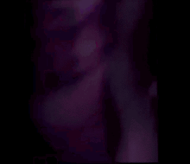 a group of people are dancing in a dark room with blue lights .