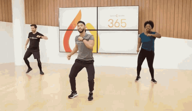 a group of people dancing in front of a screen that says 365